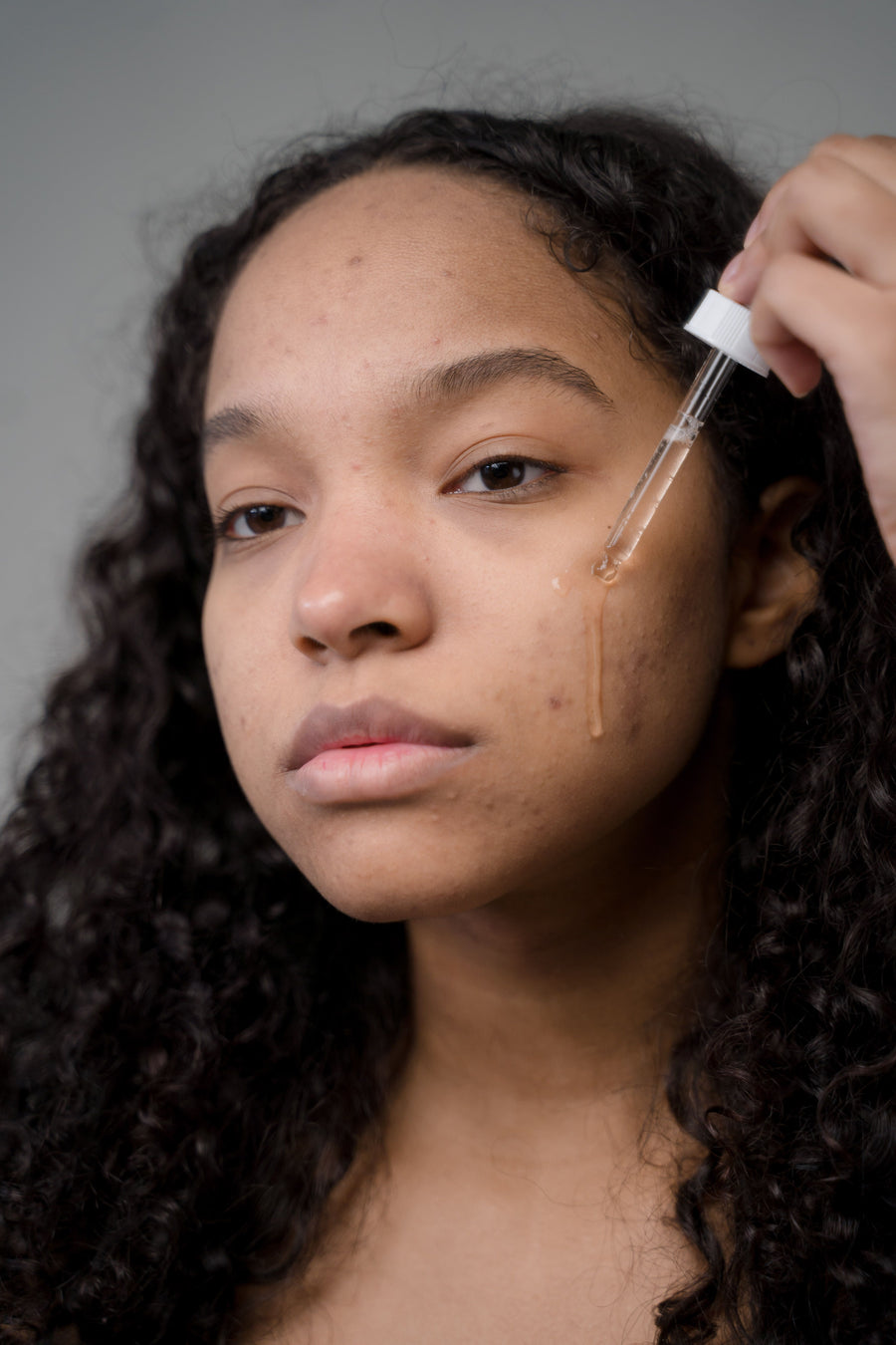 Woman applying facial serum as part of a skincare routine